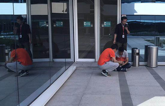 甲骨文同事在安慰被裁员员工，被裁员员工坐在地上
